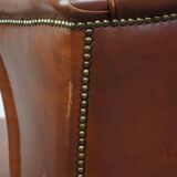 Correct, comfortable, luxurious English-style wingback armchair made of cognac-colored cow leather