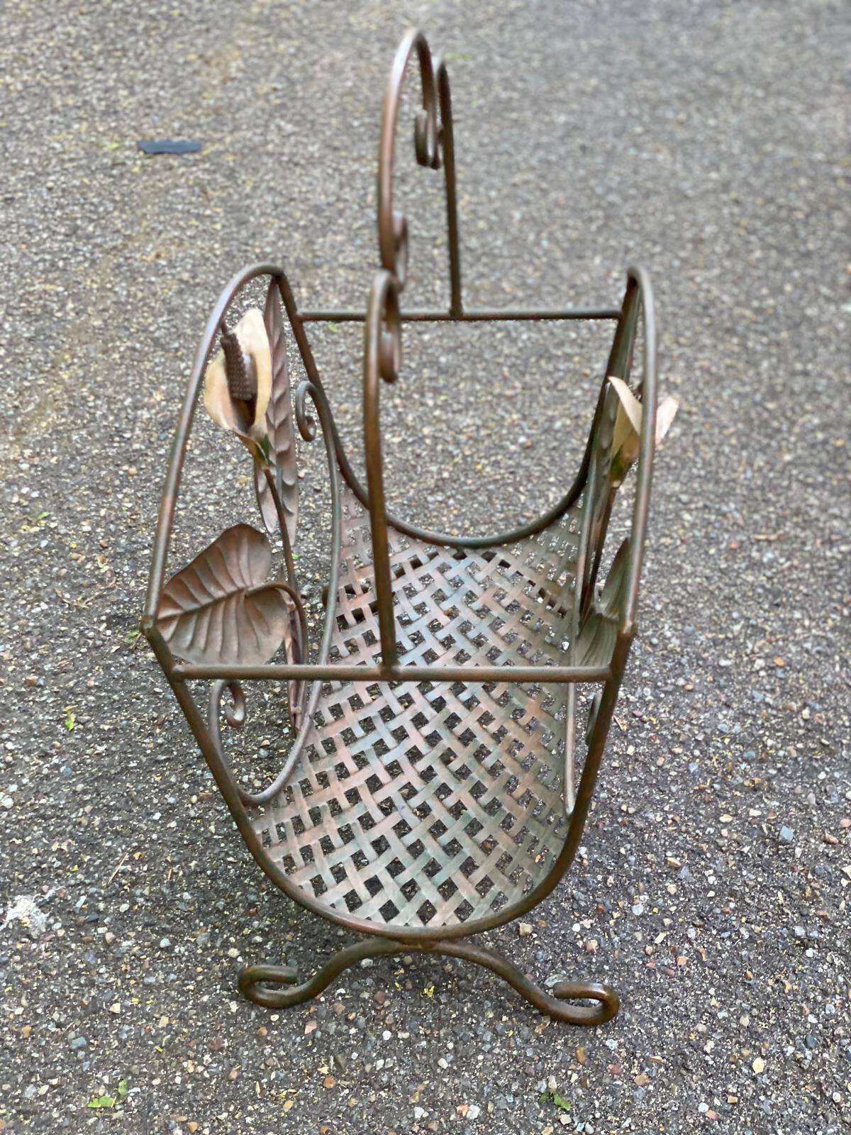 Vintage wrought iron magazine rack with flower pattern.