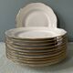 Série de 11 assiettes plates anciennes en porcelaine blanche et liserés dorés