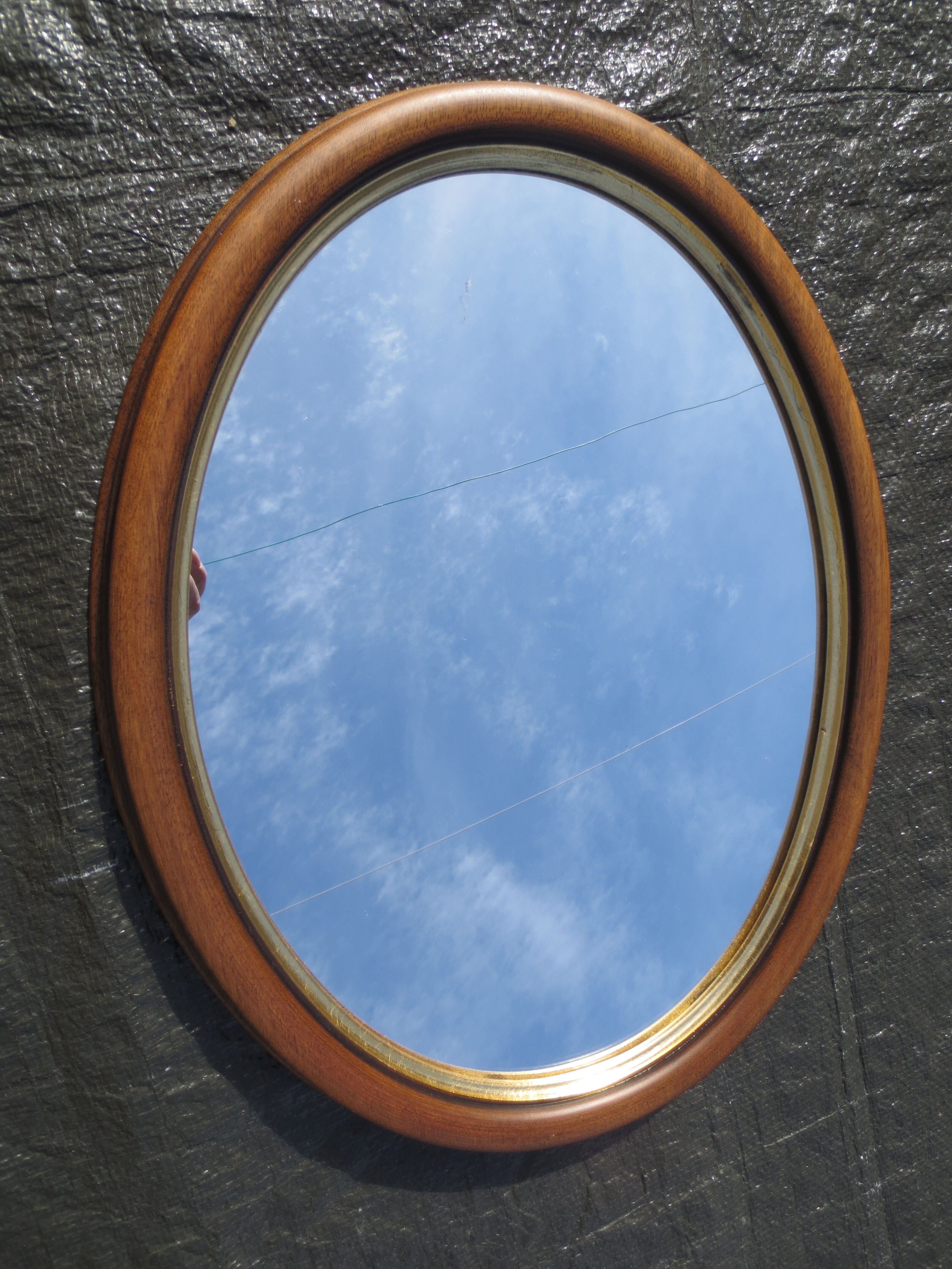 Old oval mirror, walnut wood tower, gilded border