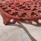 Vintage oval dark coral pink cast iron trivet