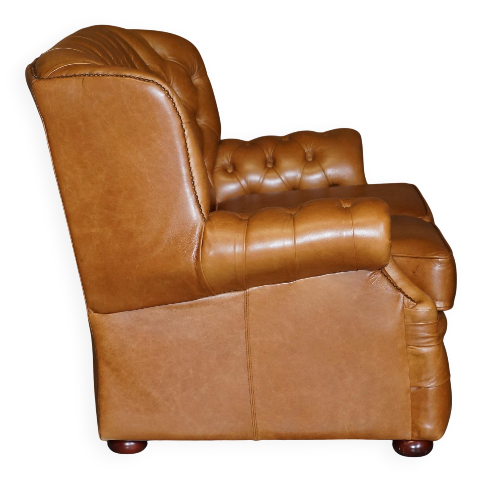 Small Chesterfield leather sofa with a high back.