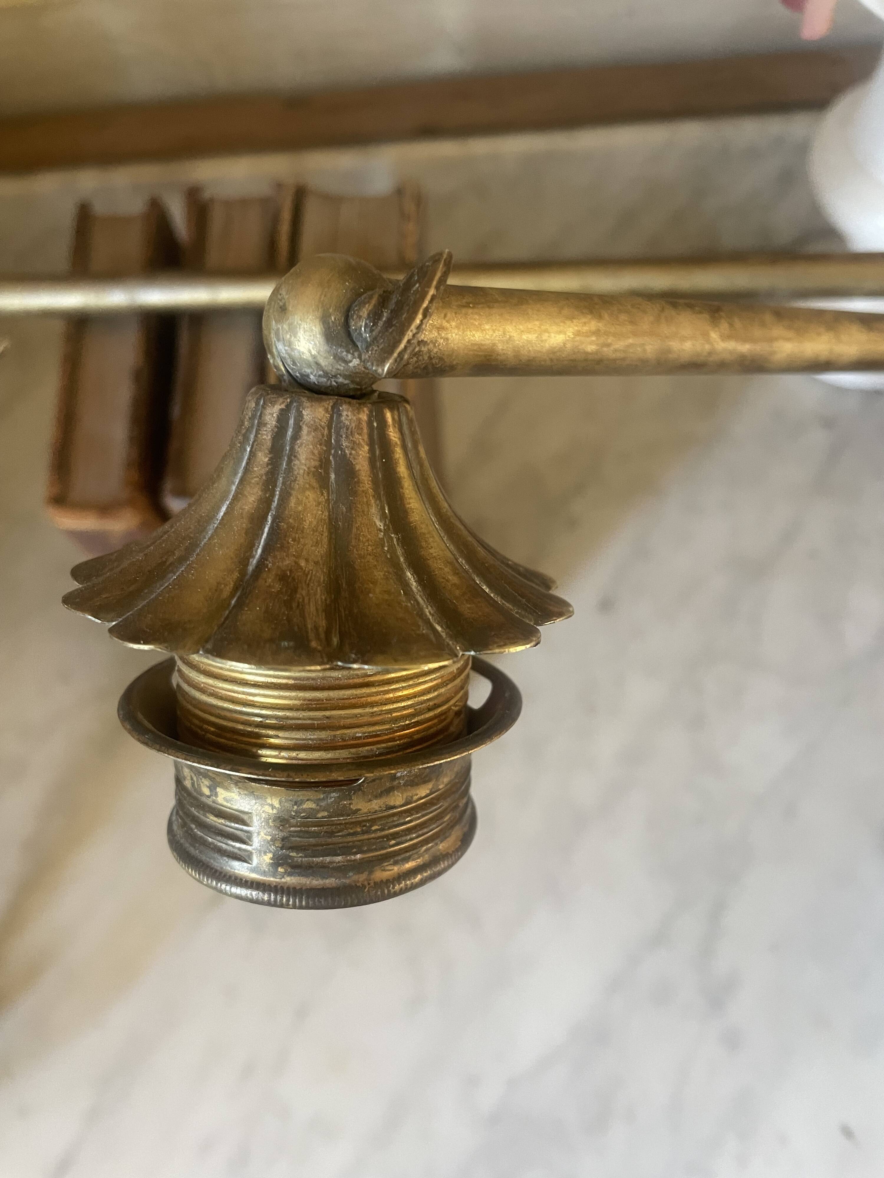 Adjustable wall light in brass and gold metal.