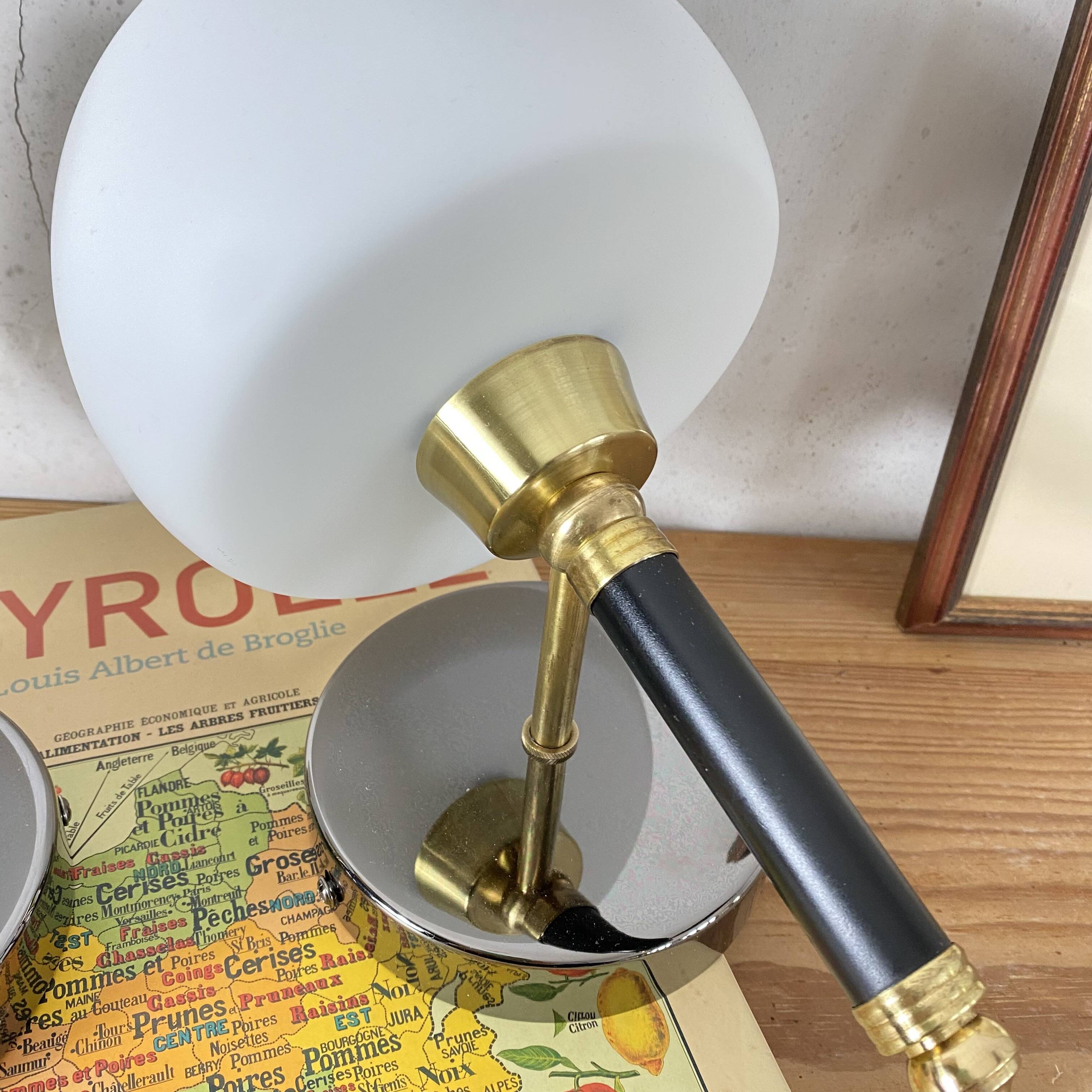 Pair of wall sconces with brass torch and white glass globe.