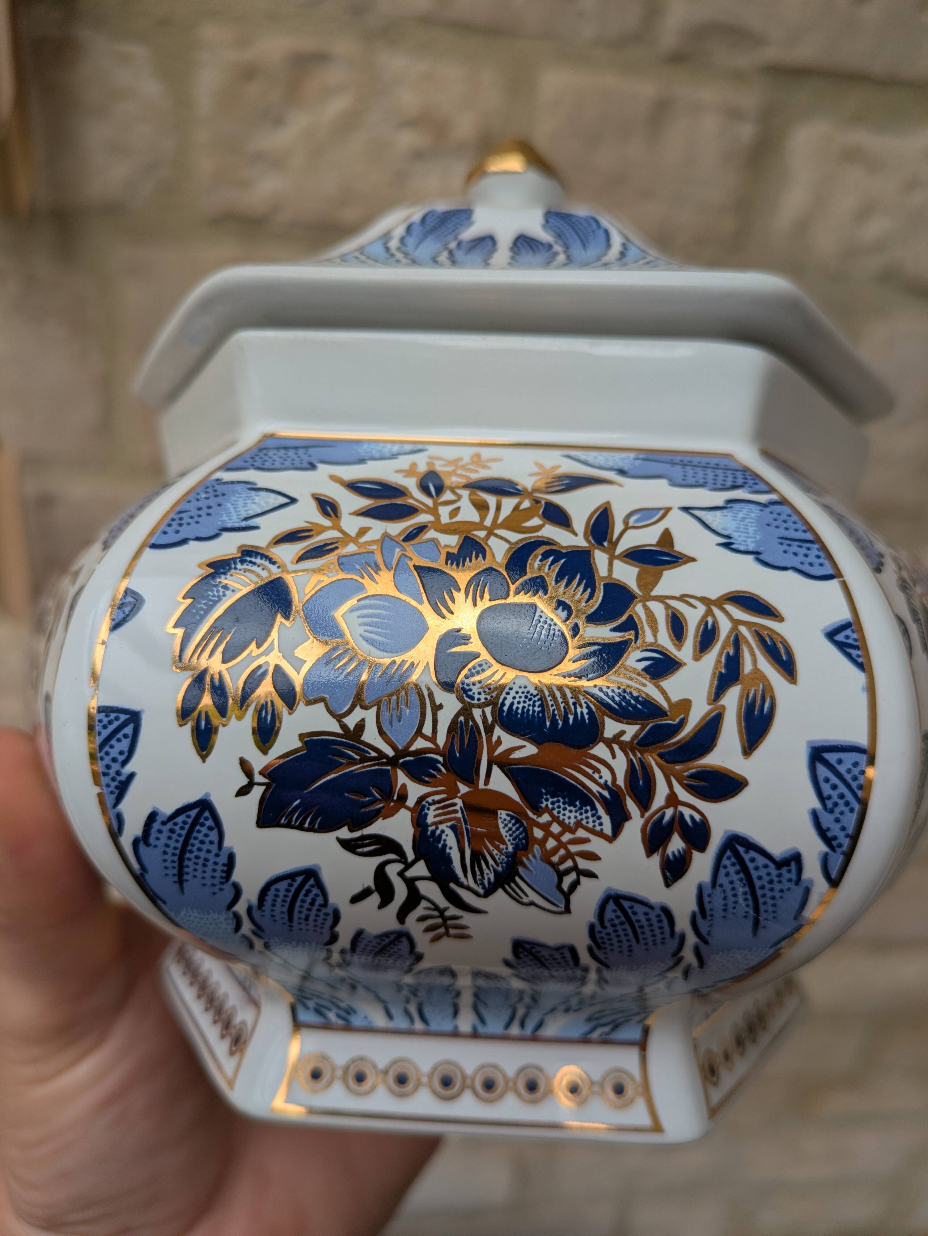 Decorative pot jar with a lid featuring a blue floral pattern and gilding.