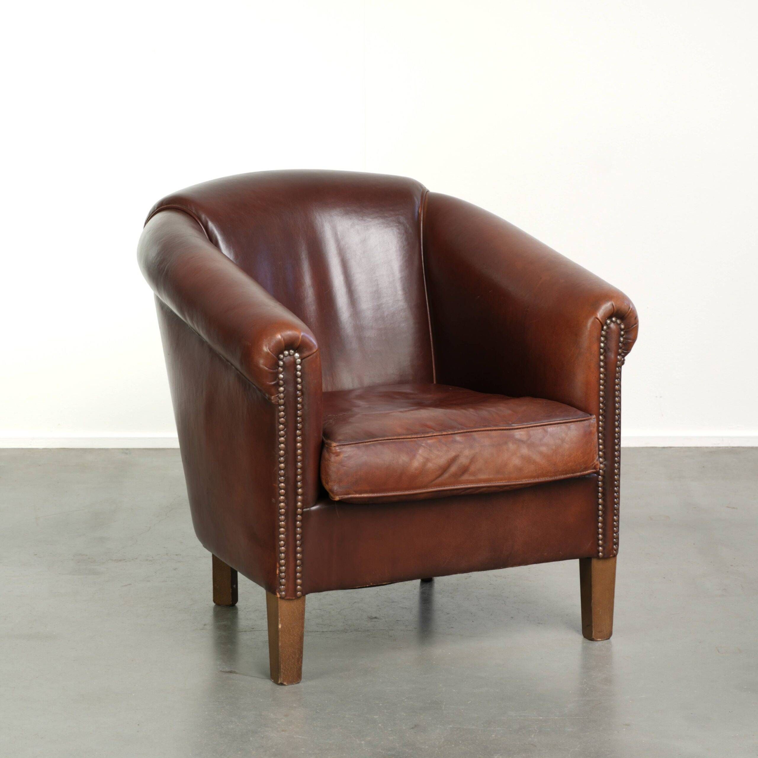 Characterful sheepskin club armchair in a dark cognac colour in English style
