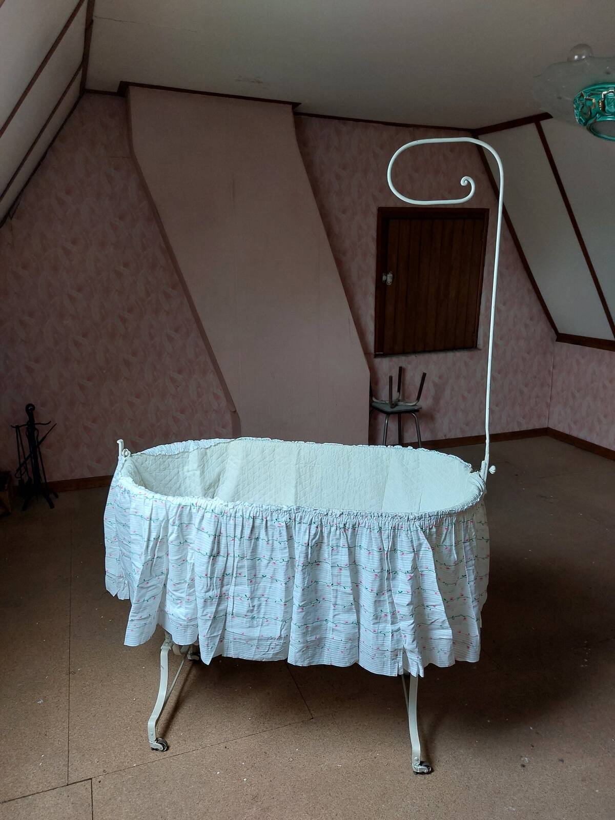Wrought iron crib painted white from around 1920 with bedding.