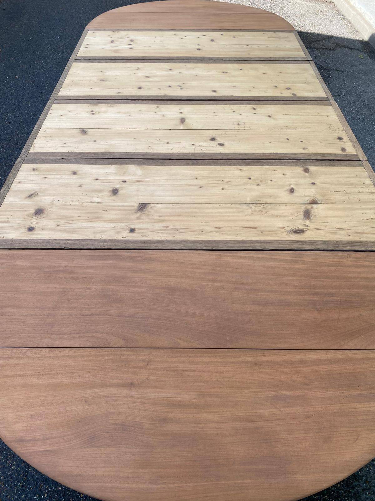 Round extendable banquet table stripped in solid mahogany with 4 extensions, 19th century.