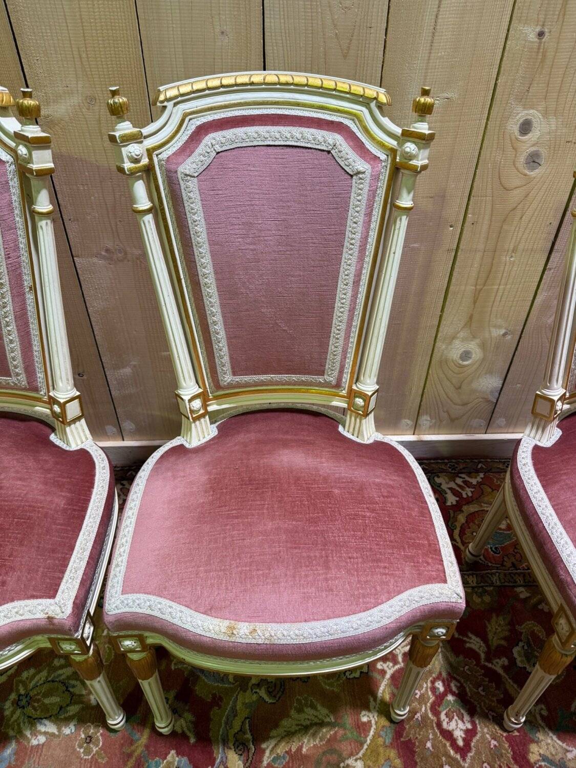 Louis XVI dining room table set with painted wood, gold accents, and pink velvet.