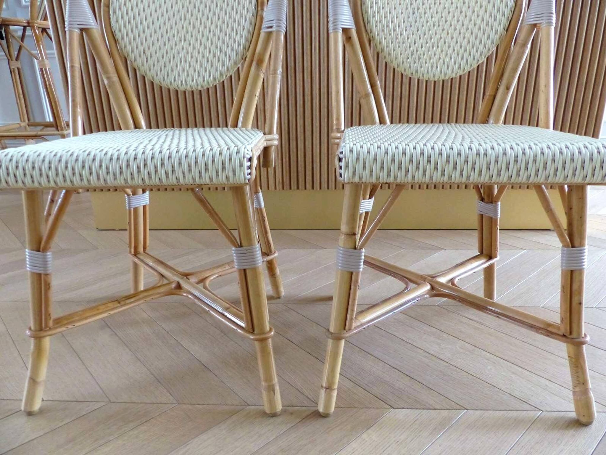 Pair of Parisian bistro chairs from Maison Louis Drucker in light Manila rattan.