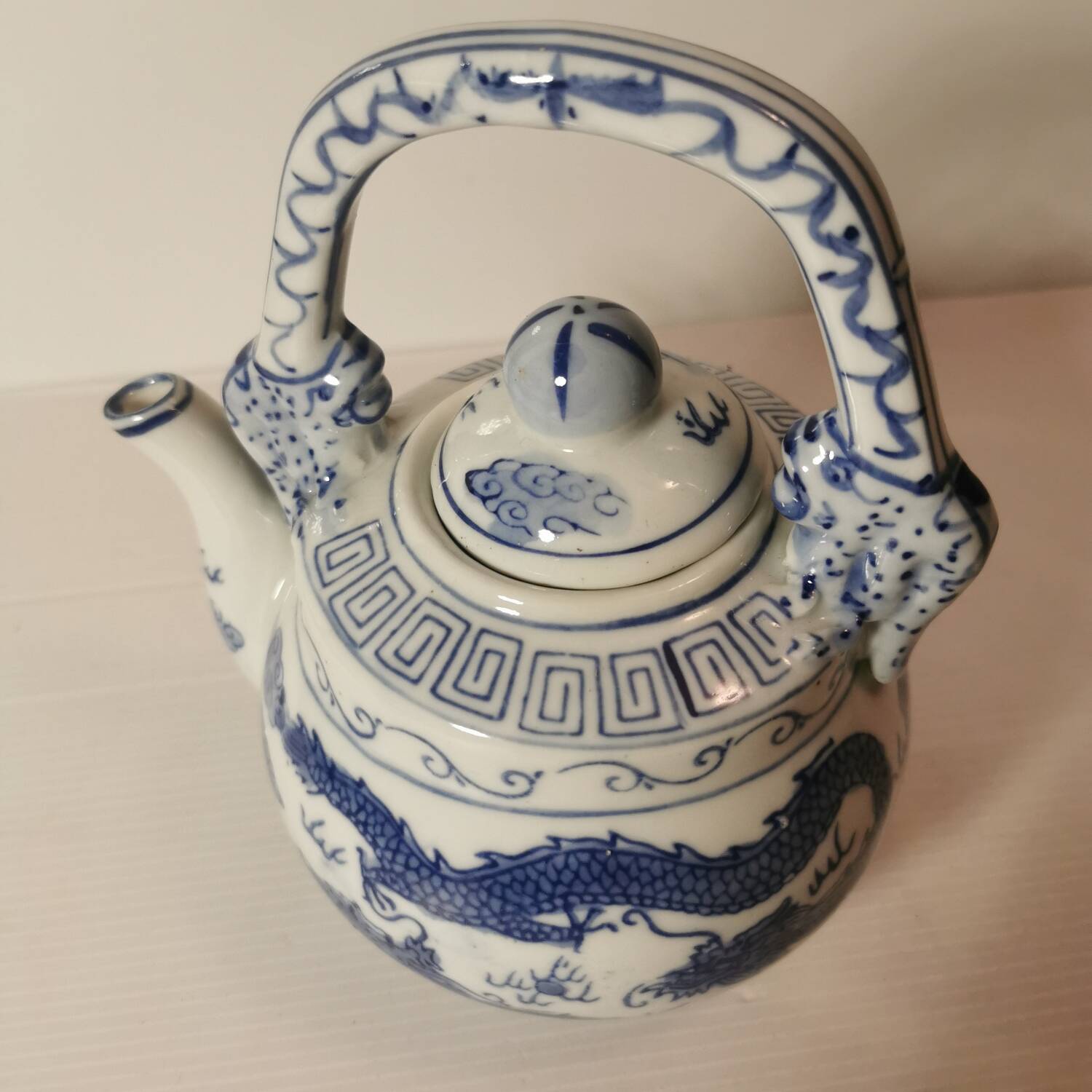 Old Chinese blue and white teapot in vintage ceramic with dragon decor