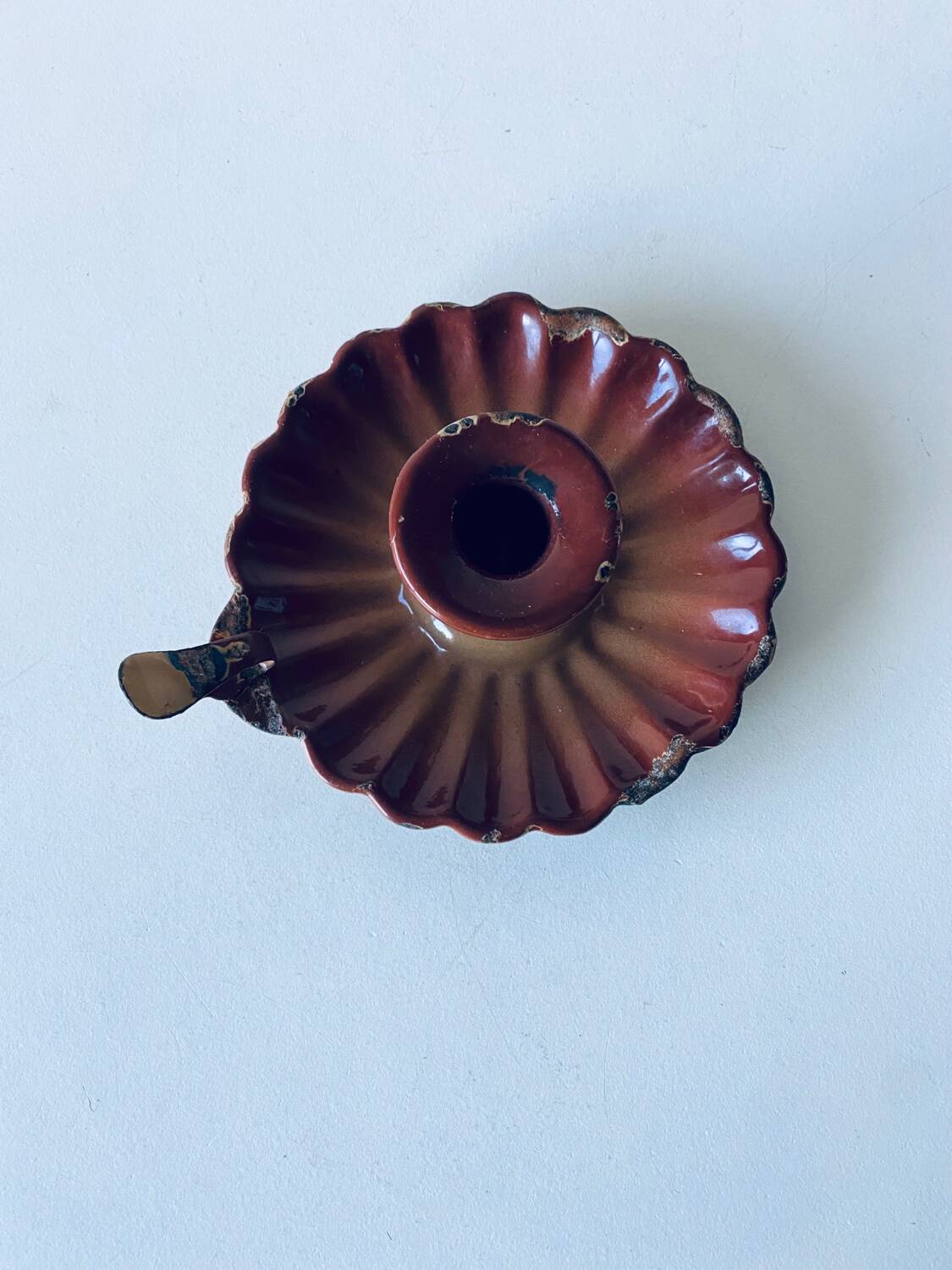 Old candle holder in brown enameled metal