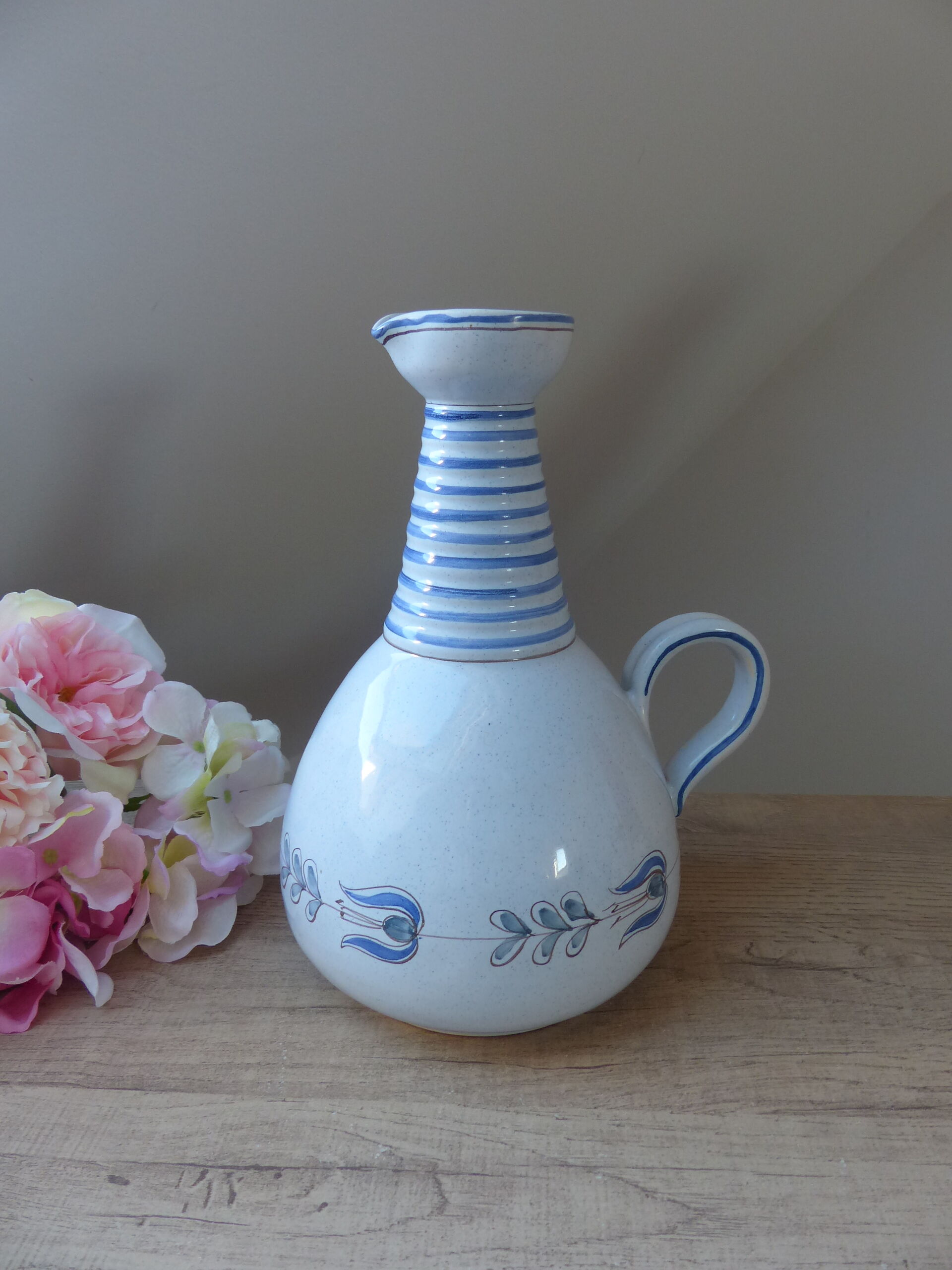 Vintage blue ceramic jug with hand-painted floral decoration.