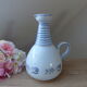 Vintage blue ceramic jug with hand-painted floral decoration.