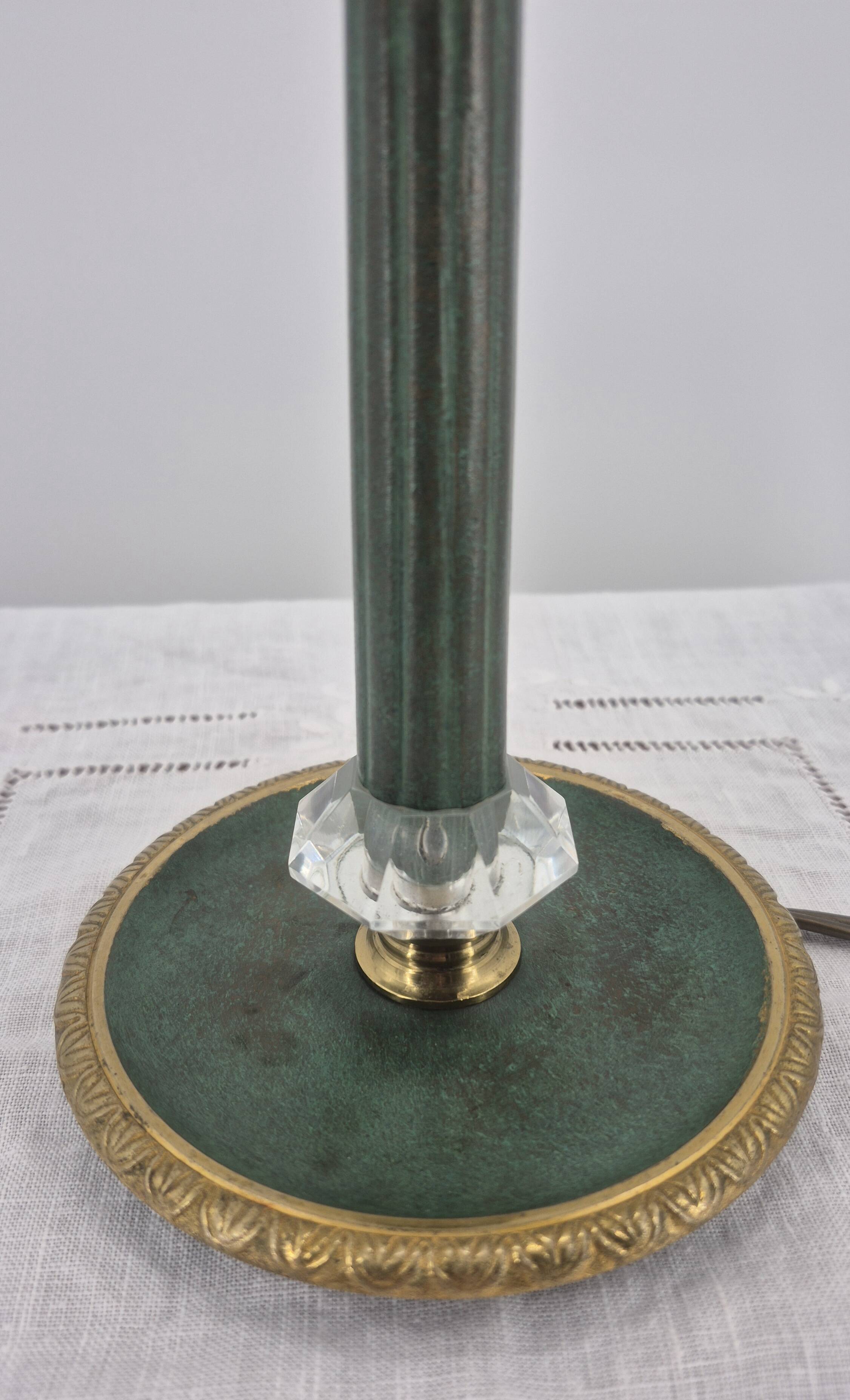 Brass table lamp with green patina and empire-style fabric shade.