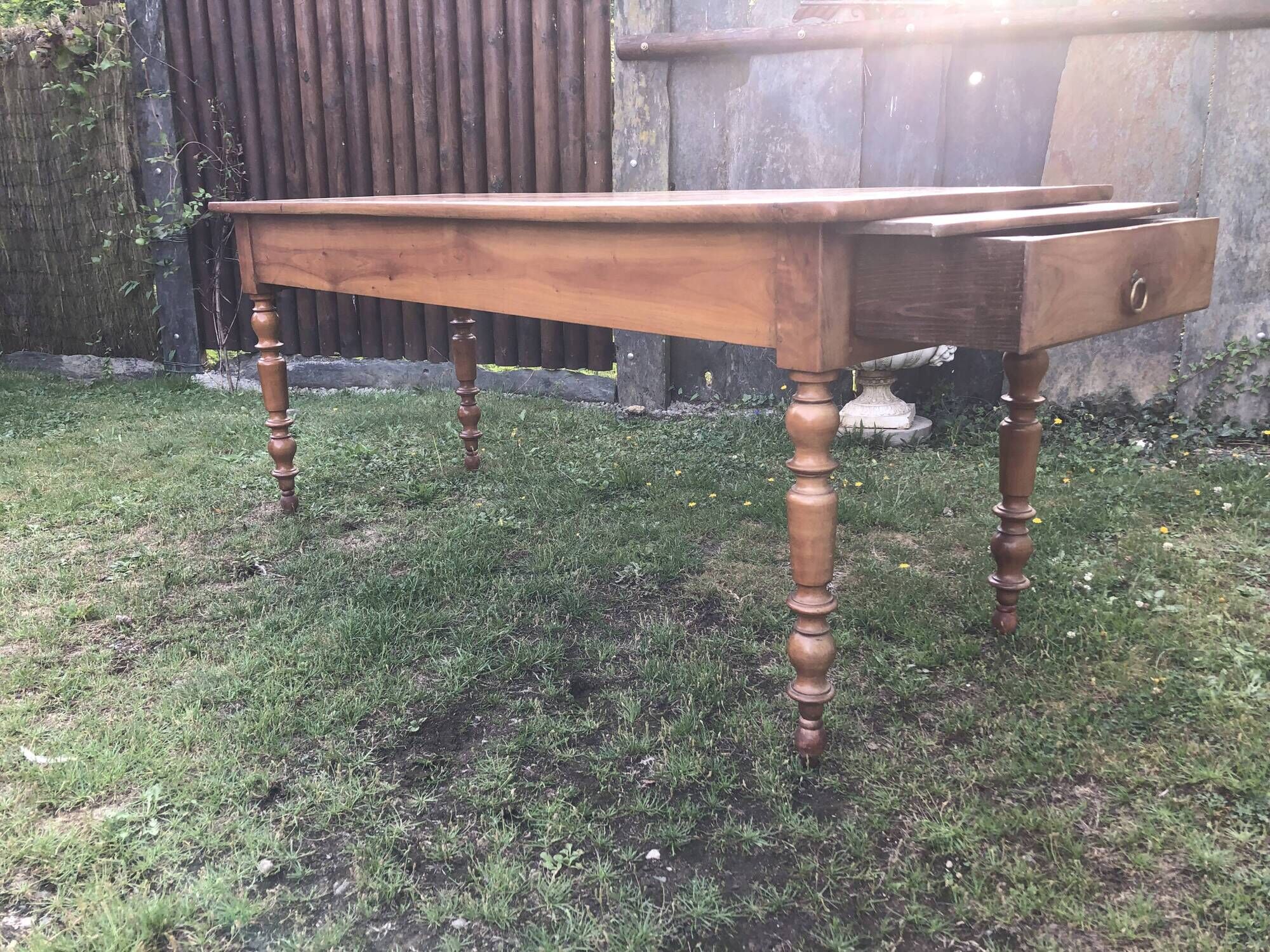 Antique farmhouse table in solid cherry wood with 2 drawers and 1 pull-out at the end with turned legs.