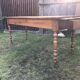 Antique farmhouse table in solid cherry wood with 2 drawers and 1 pull-out at the end with turned legs.
