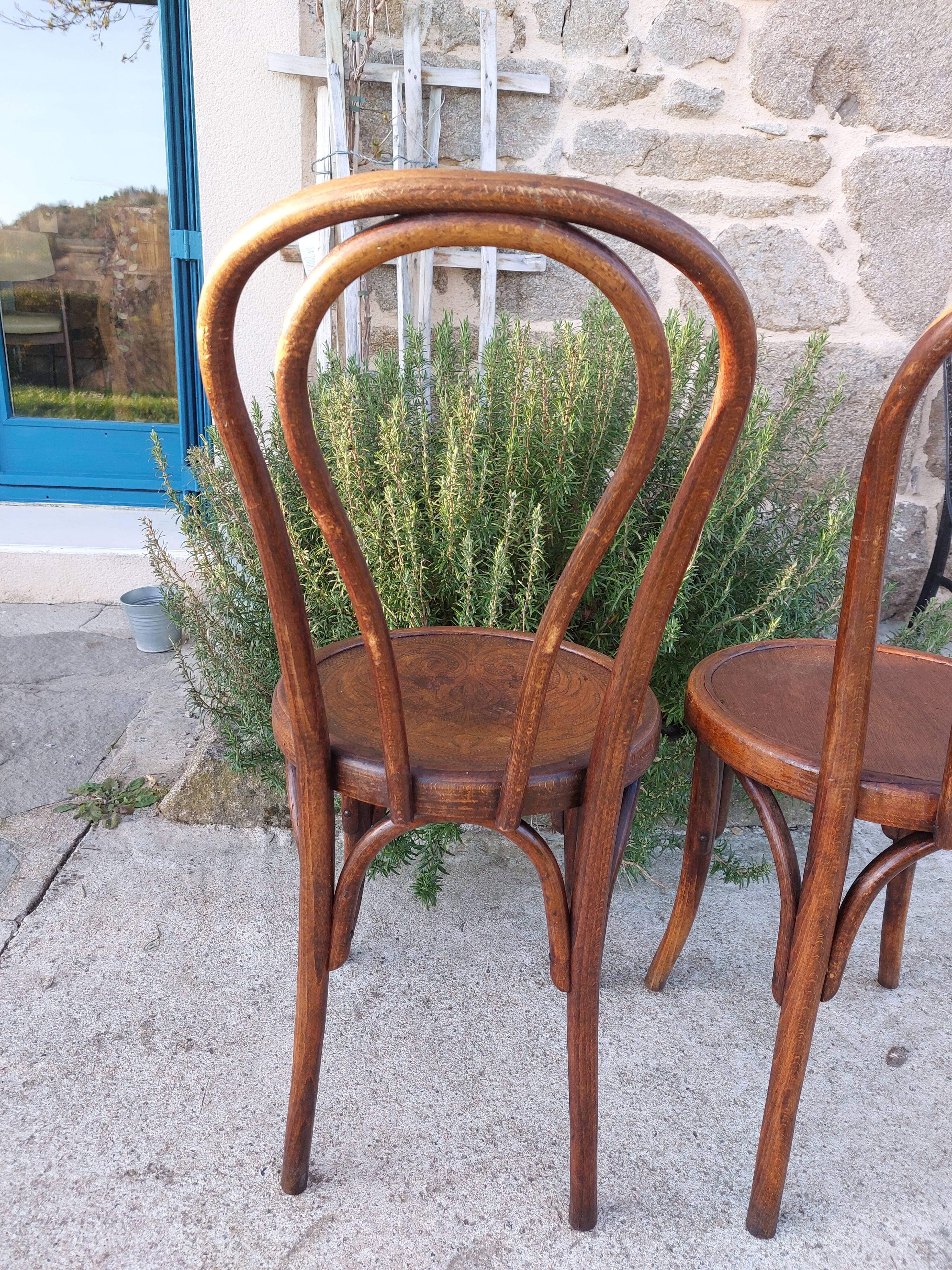 pair of round wooden chairs with a pattern on the seat