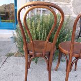 pair of round wooden chairs with a pattern on the seat