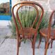 pair of round wooden chairs with a pattern on the seat