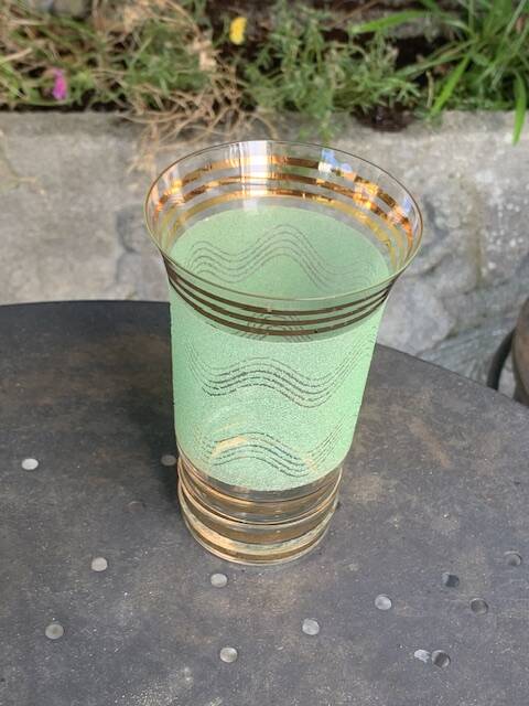 Serve an orangeade, a carafe and 3 glasses in green granite with golden trim.