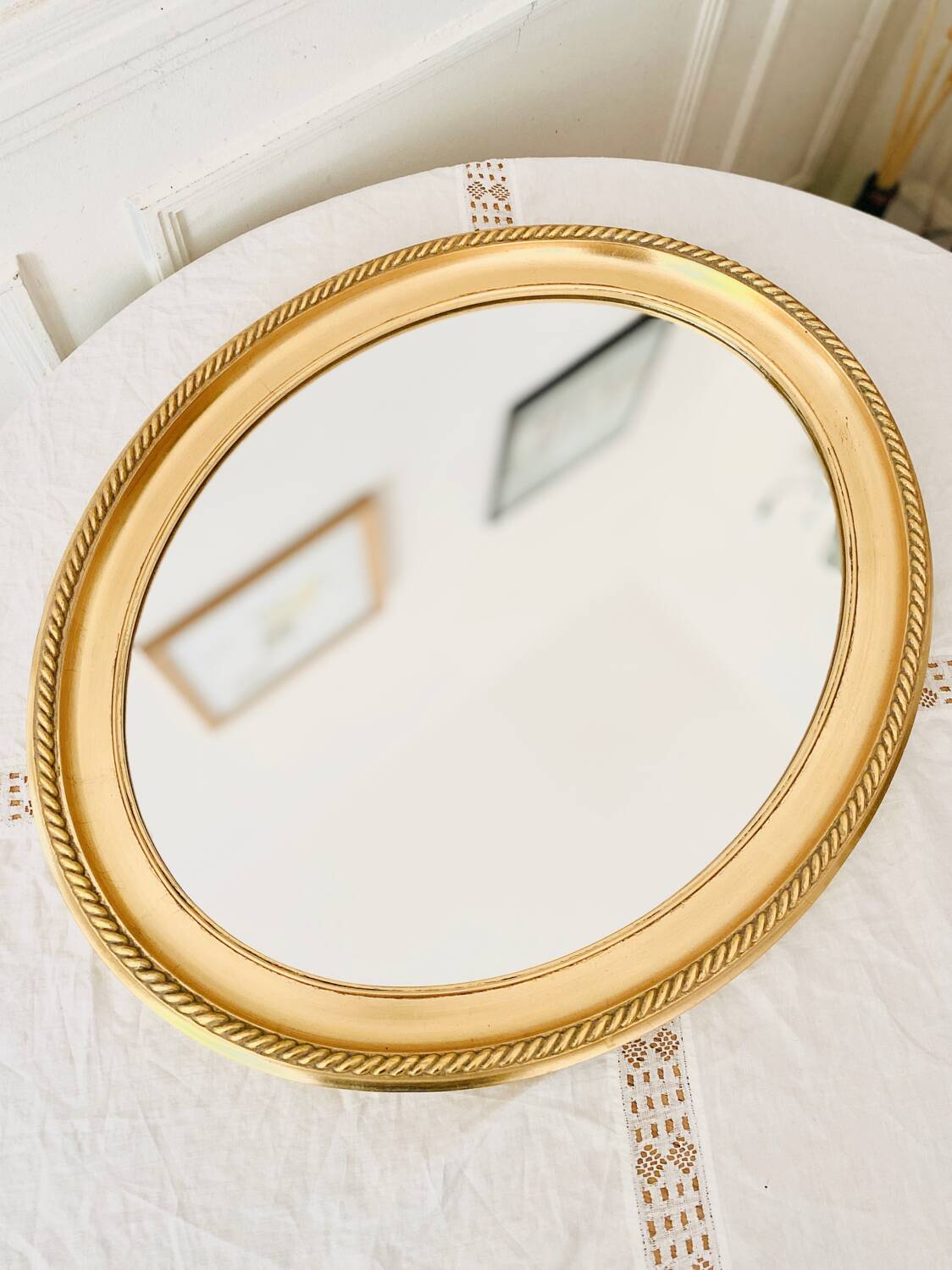 Oval wall mirror in gilded wood