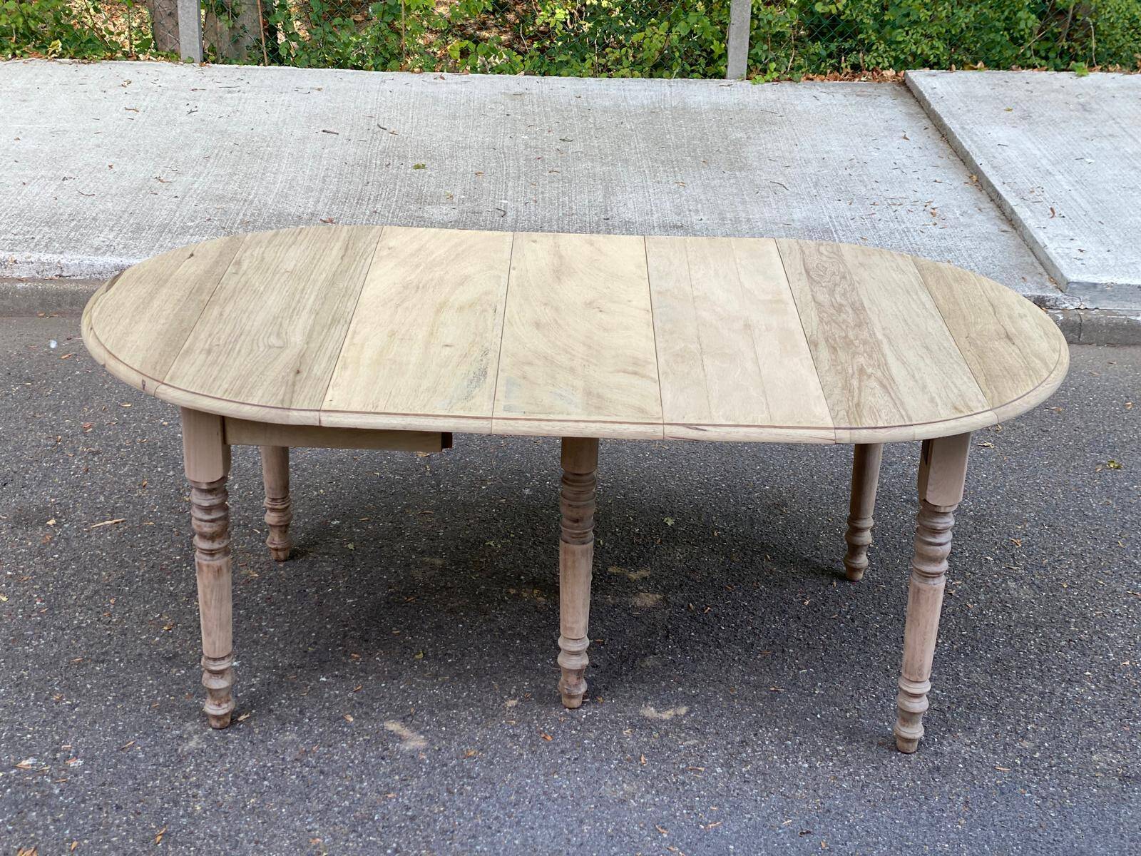 Round extendable dining table with flaps, stripped in raw oak, with 3 extensions.