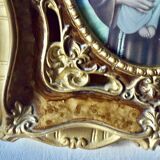 Old religious light frame in gilded stucco and curved glass