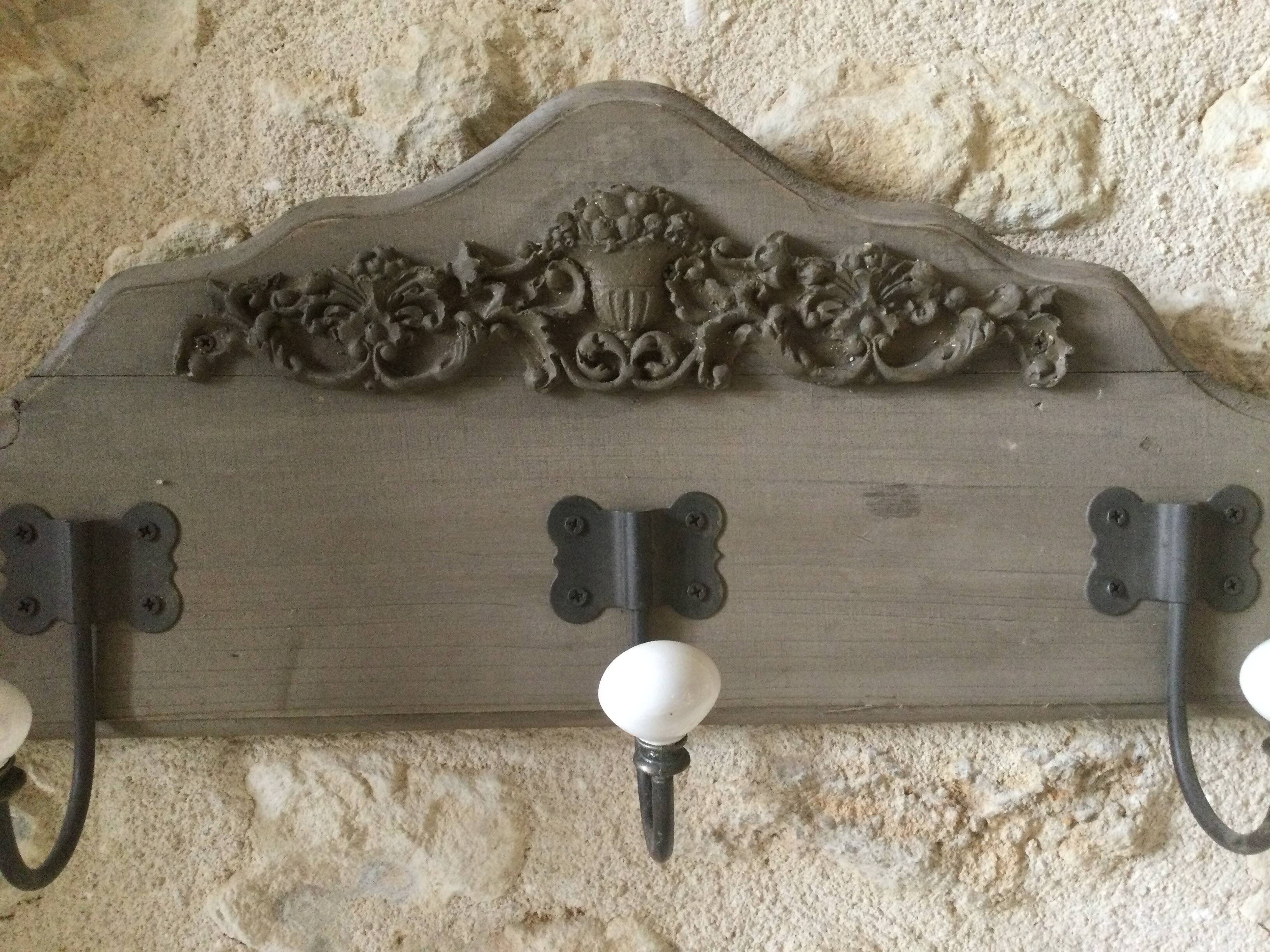 Wall-mounted wooden coat rack with 3 hooks.