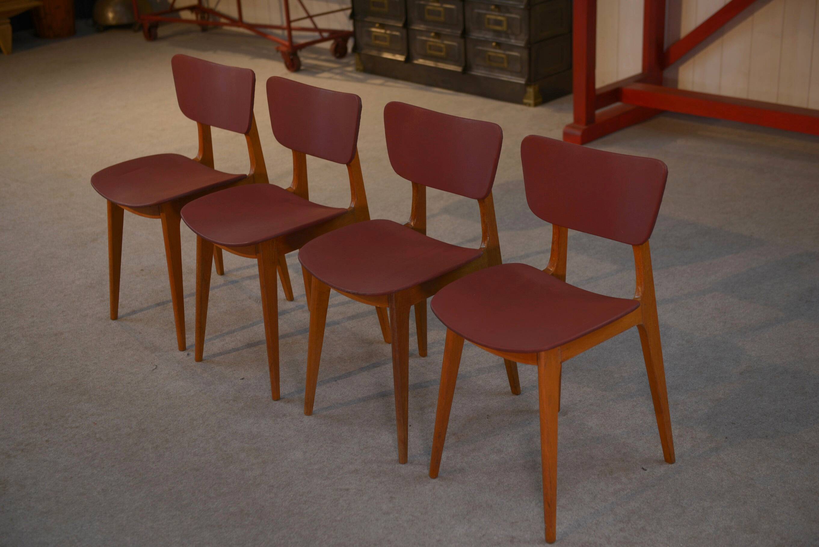 Set of 4 designer chairs in oak and red leatherette from the 1960s
