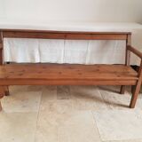 Church bench in fir tree with armrests