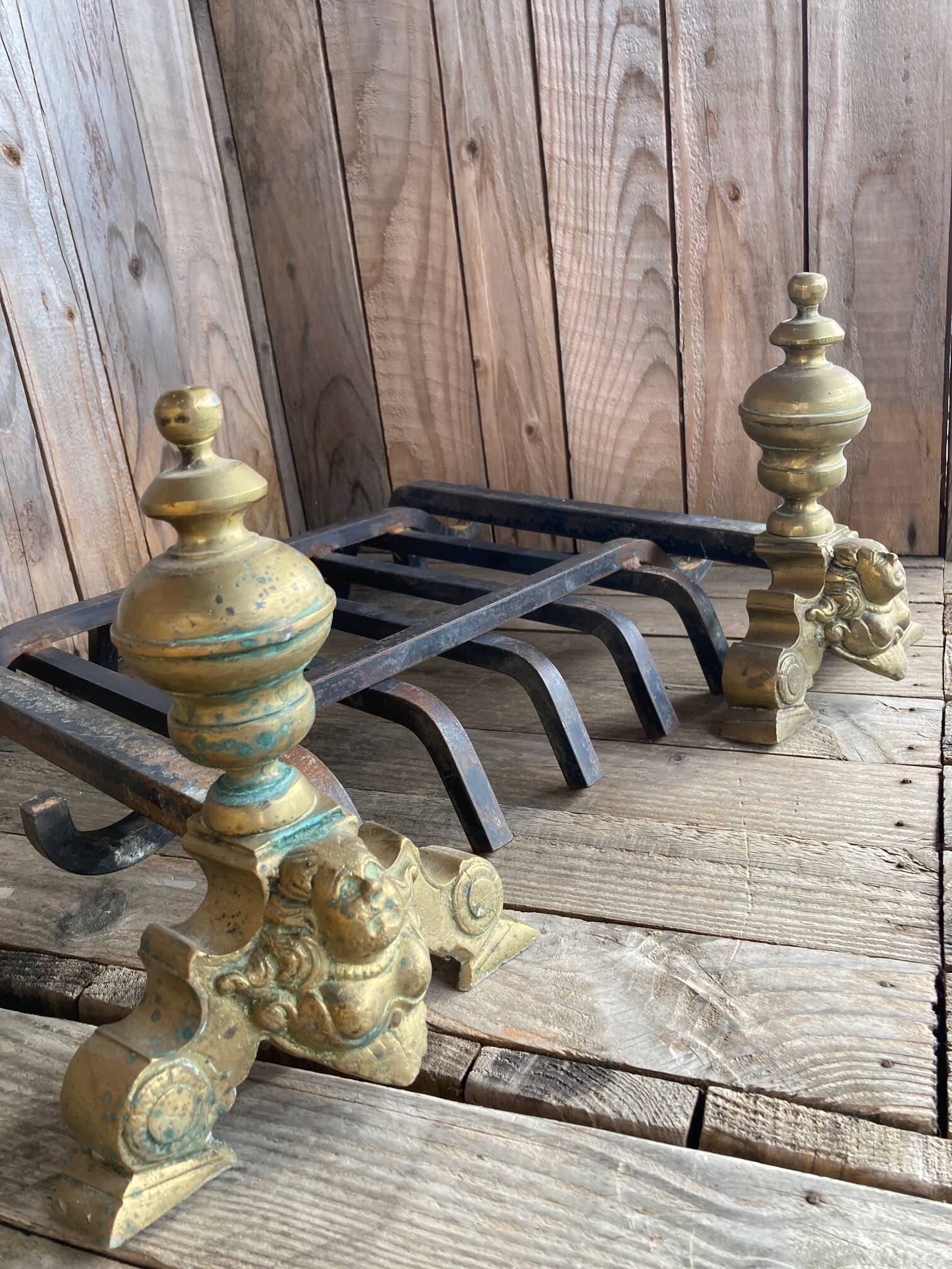 Pair of andirons and grates in cast iron and bronze with gilded grotesques, 17th century