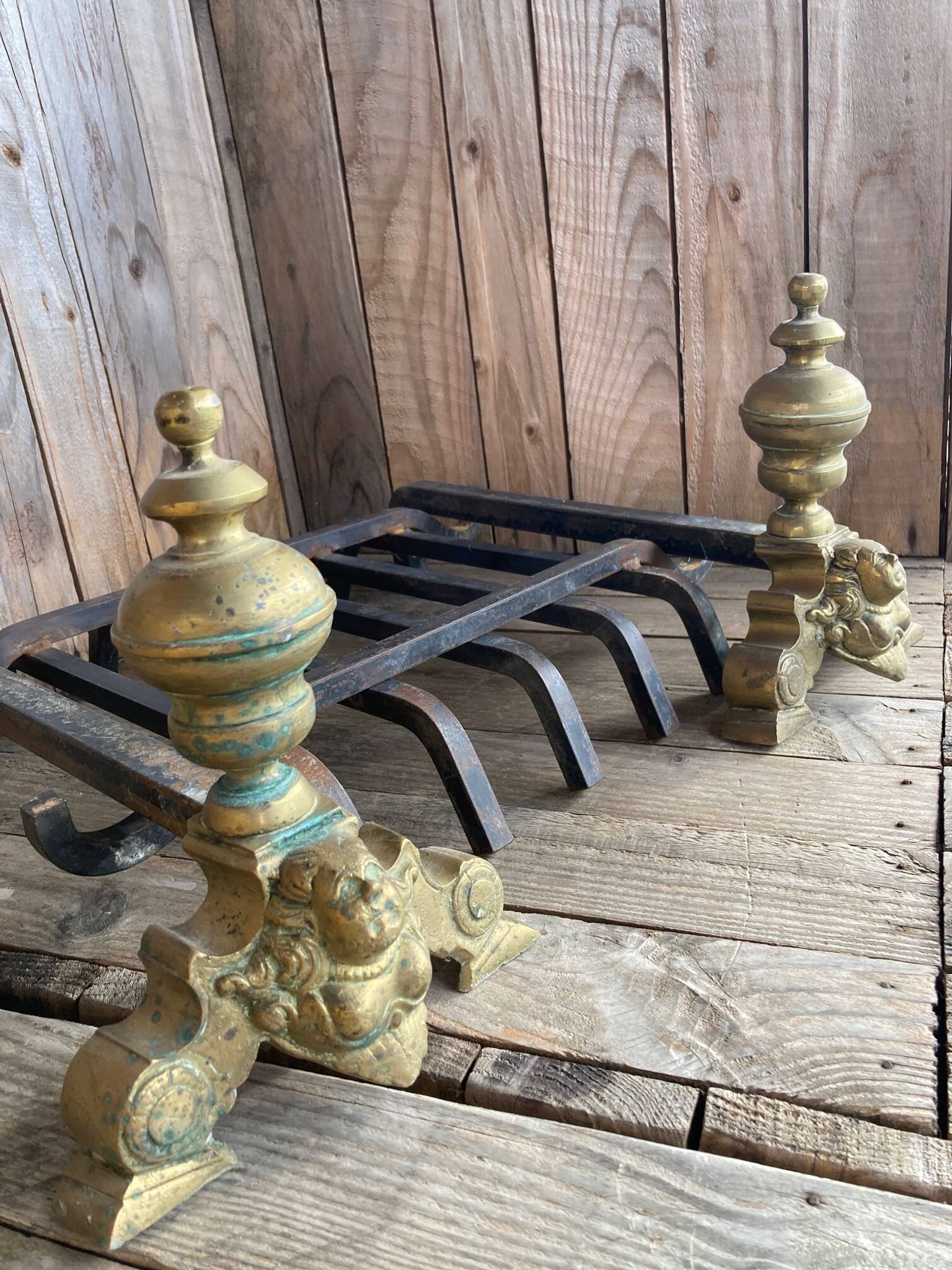 Pair of andirons and grates in cast iron and bronze with gilded grotesques, 17th century