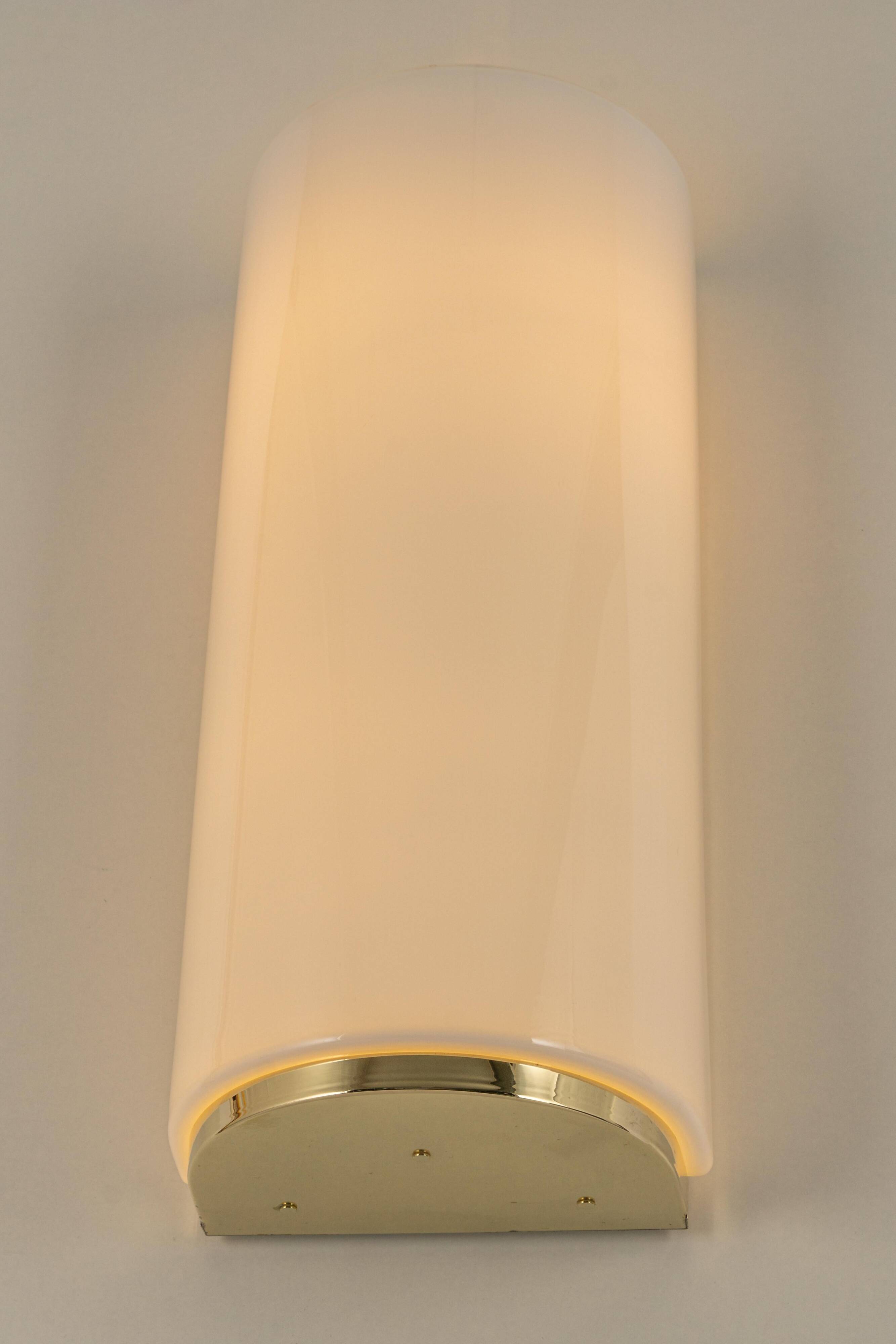 Pair of large opaline glass wall lights in brass designed by Limburg, Germany.