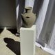 Light beige-grey Indonesian terracotta vase with 4 small handles and a high neck.