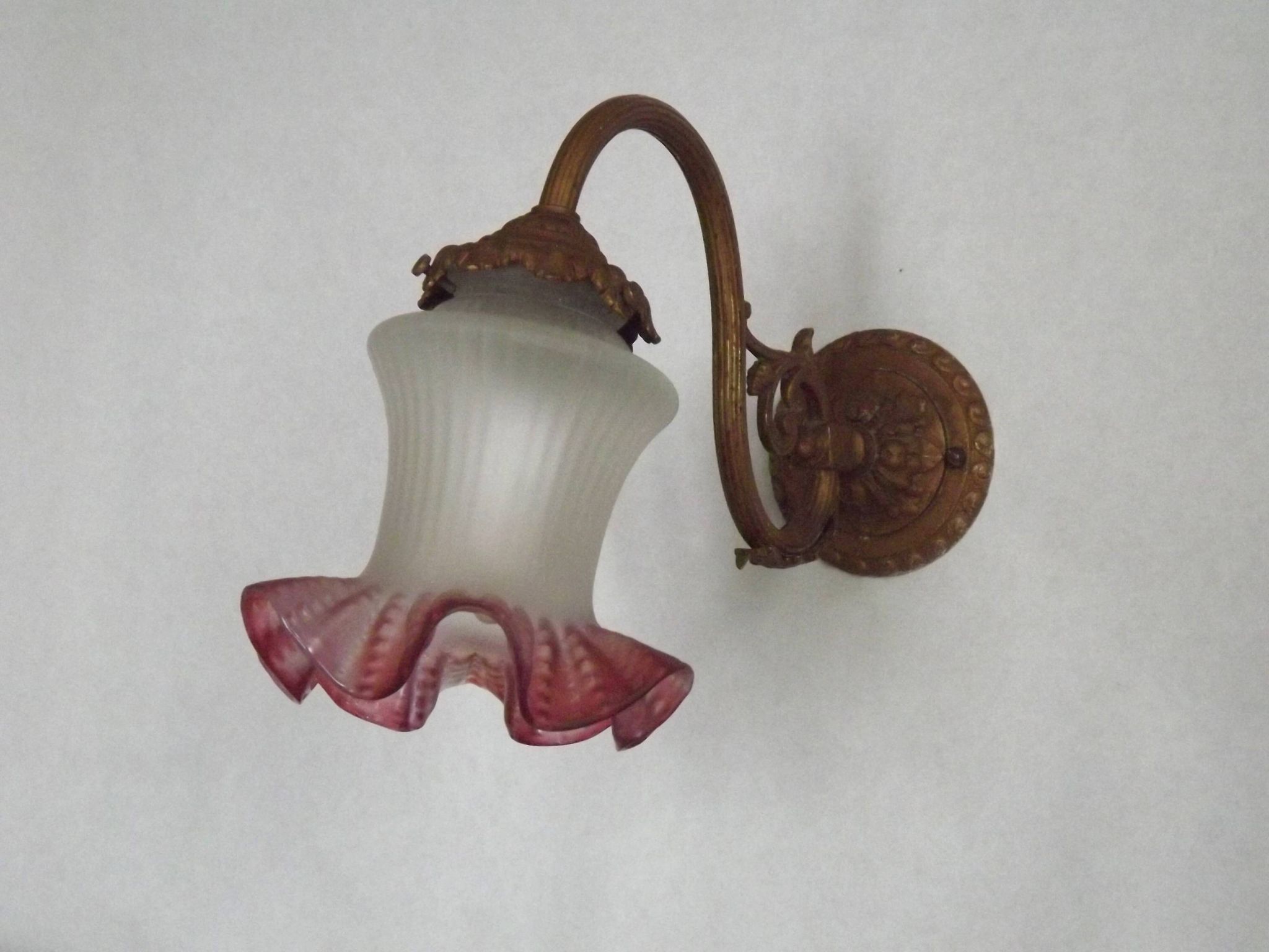 French Art Nouveau wall sconce in bronze with a white and pink glass shade.