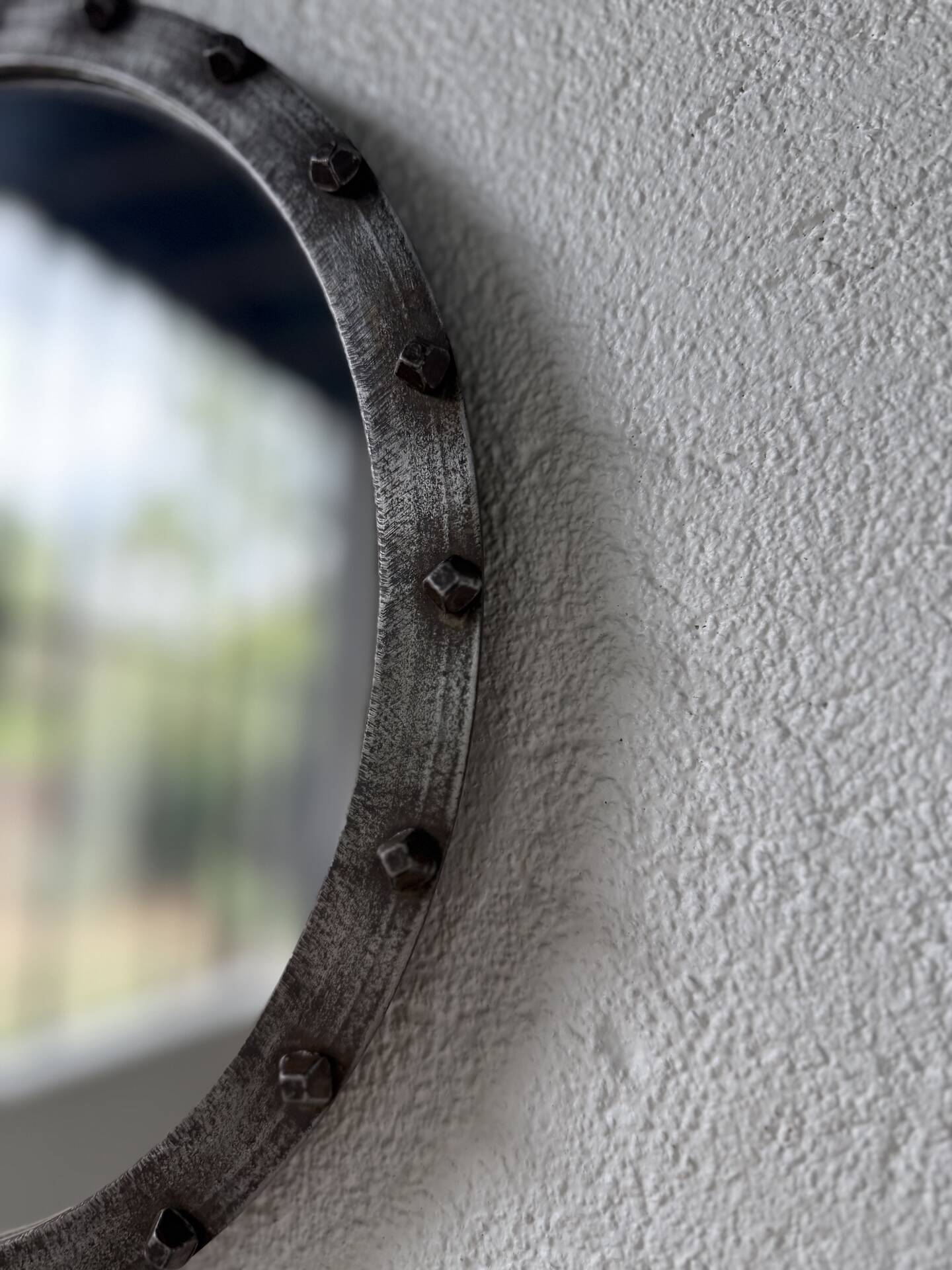 Brutalist round mirror with wrought iron and studs.