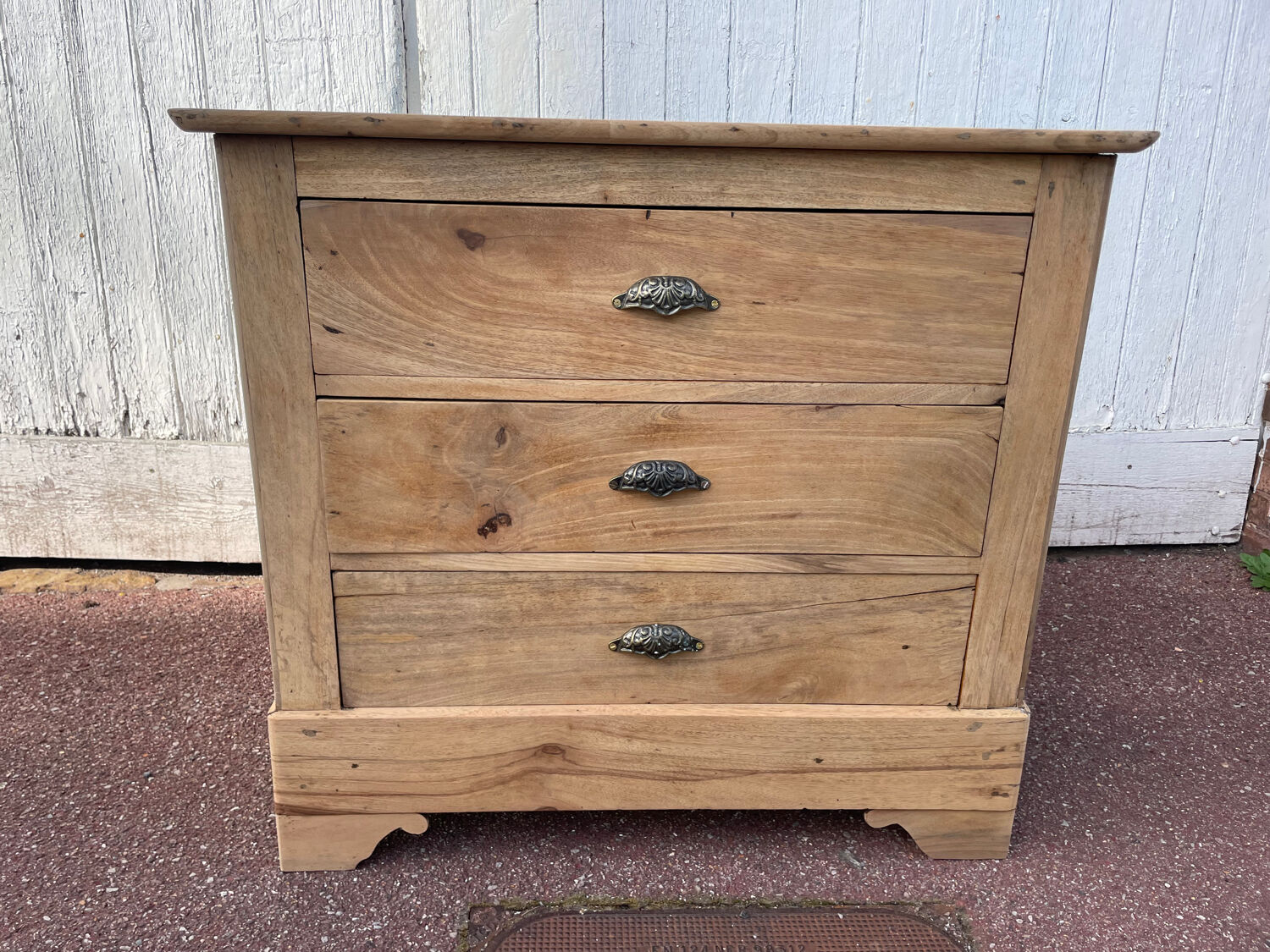 Raw wood chest of drawers with three drawers and shell handles.