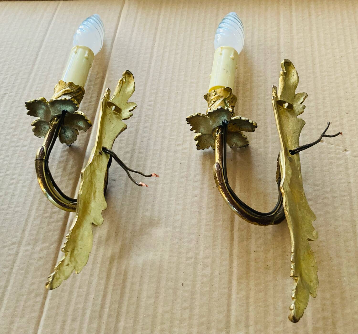 Bronze wall lights in the Louis XV style with curved branches and leaf decorations.