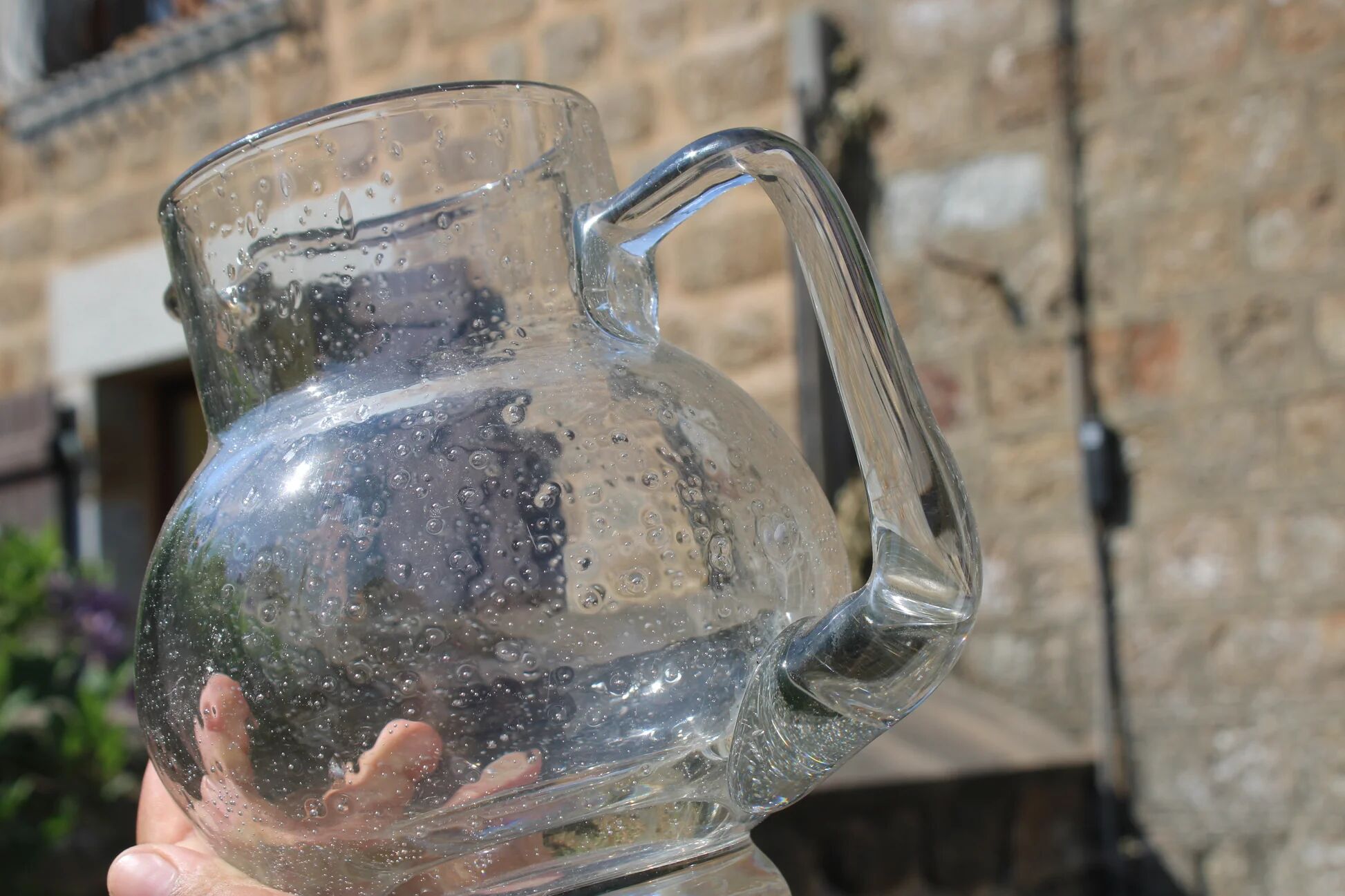 Vintage blown glass pitcher with bubbles, transparent.