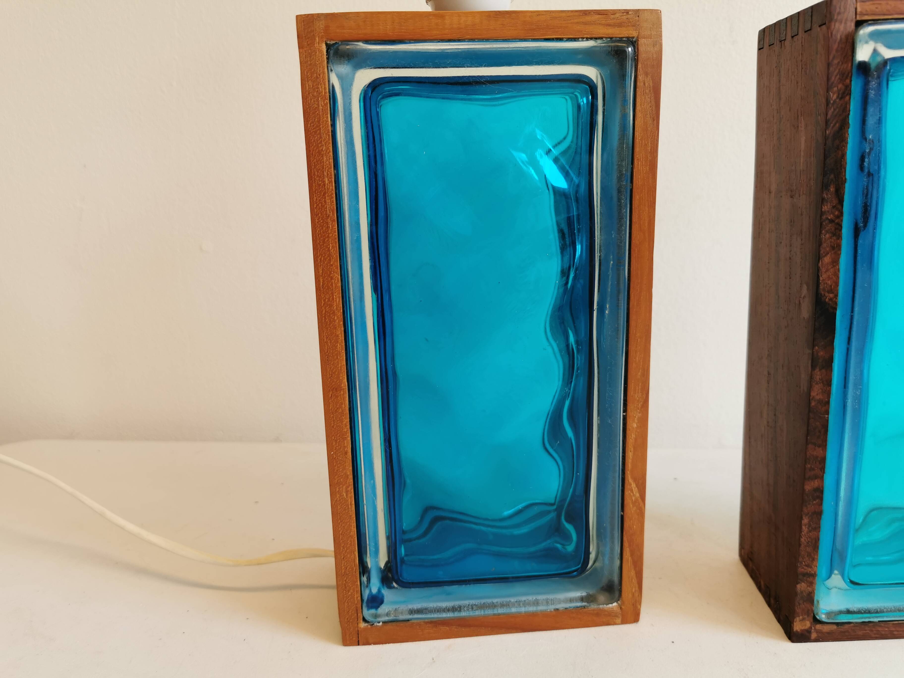 Two Swedish table lamps in solid pressed blue glass and teak wood "frame".