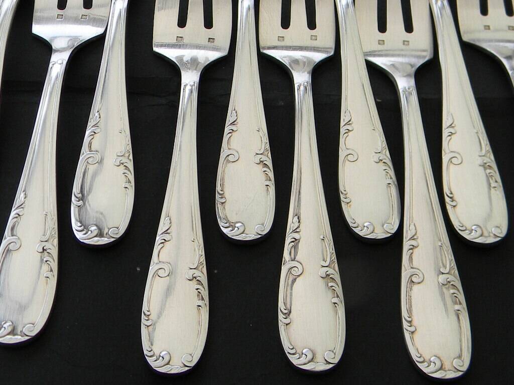 12 cake forks and a silver metal server.