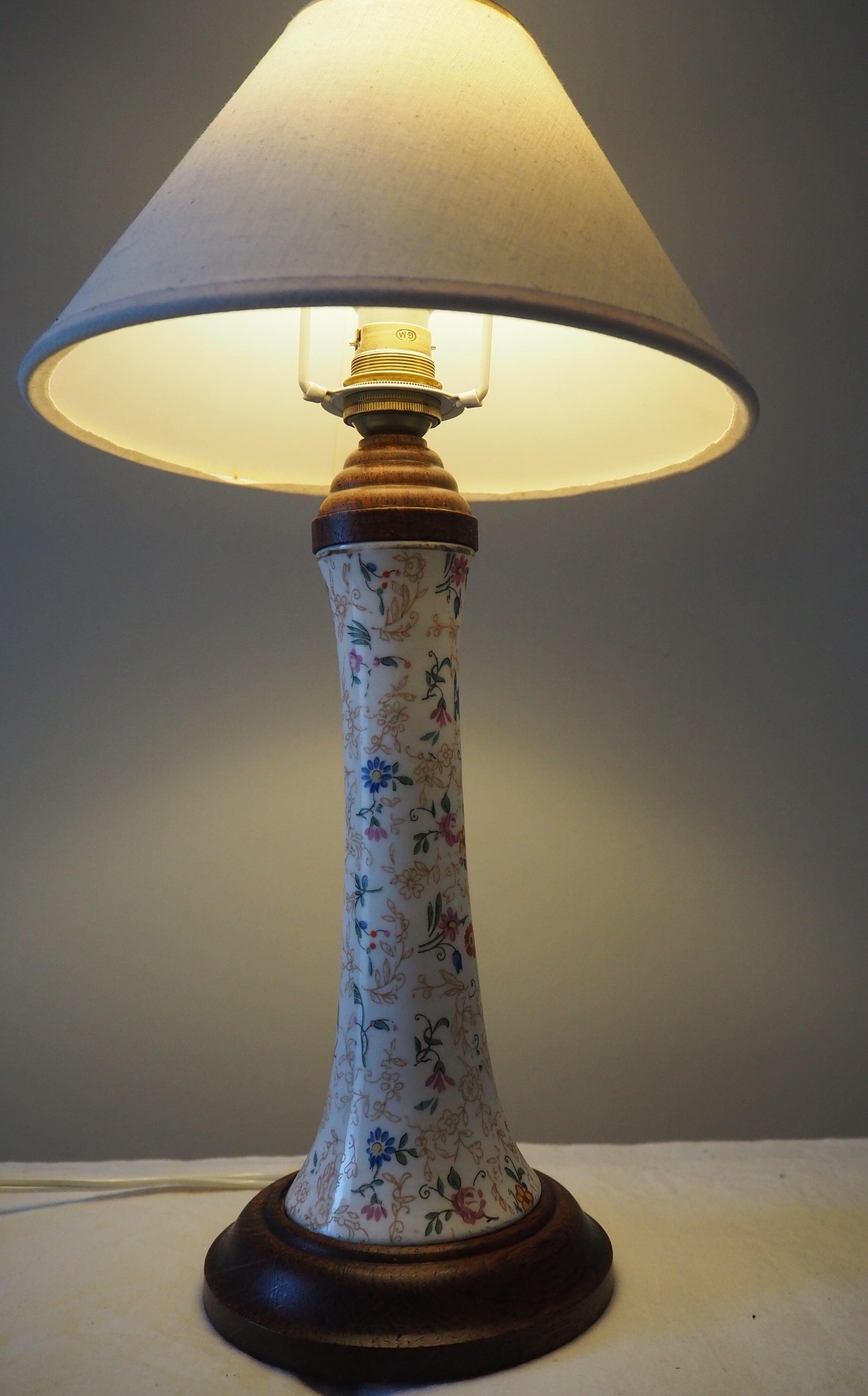 Table lamp for bedside use in earthenware with a wooden base.