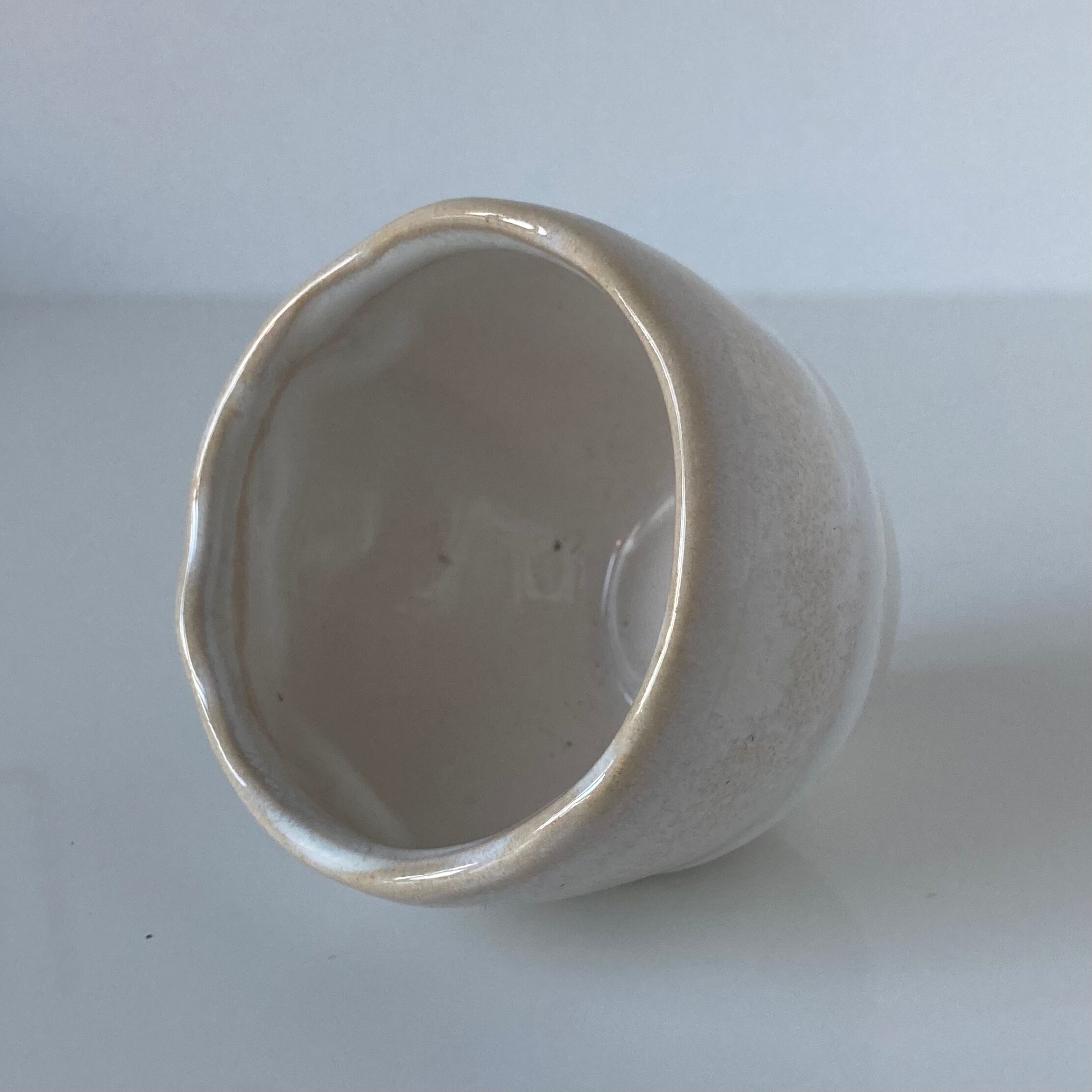 Meeting of three artist's ceramic objects including two pots and a cream covered bowl