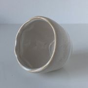 Meeting of three artist's ceramic objects including two pots and a cream covered bowl