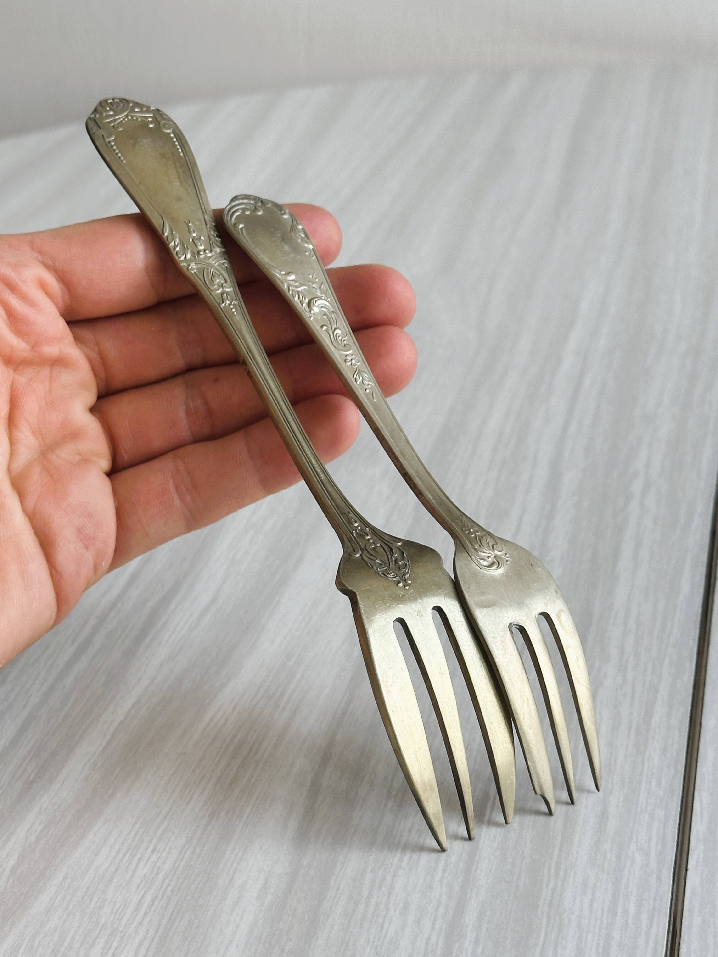 Paire de fourchettes en métal argenté, design orné