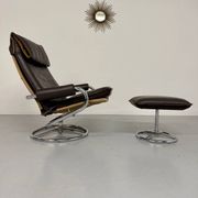 Vintage leather reclining armchair and its 1970s designer ottoman.