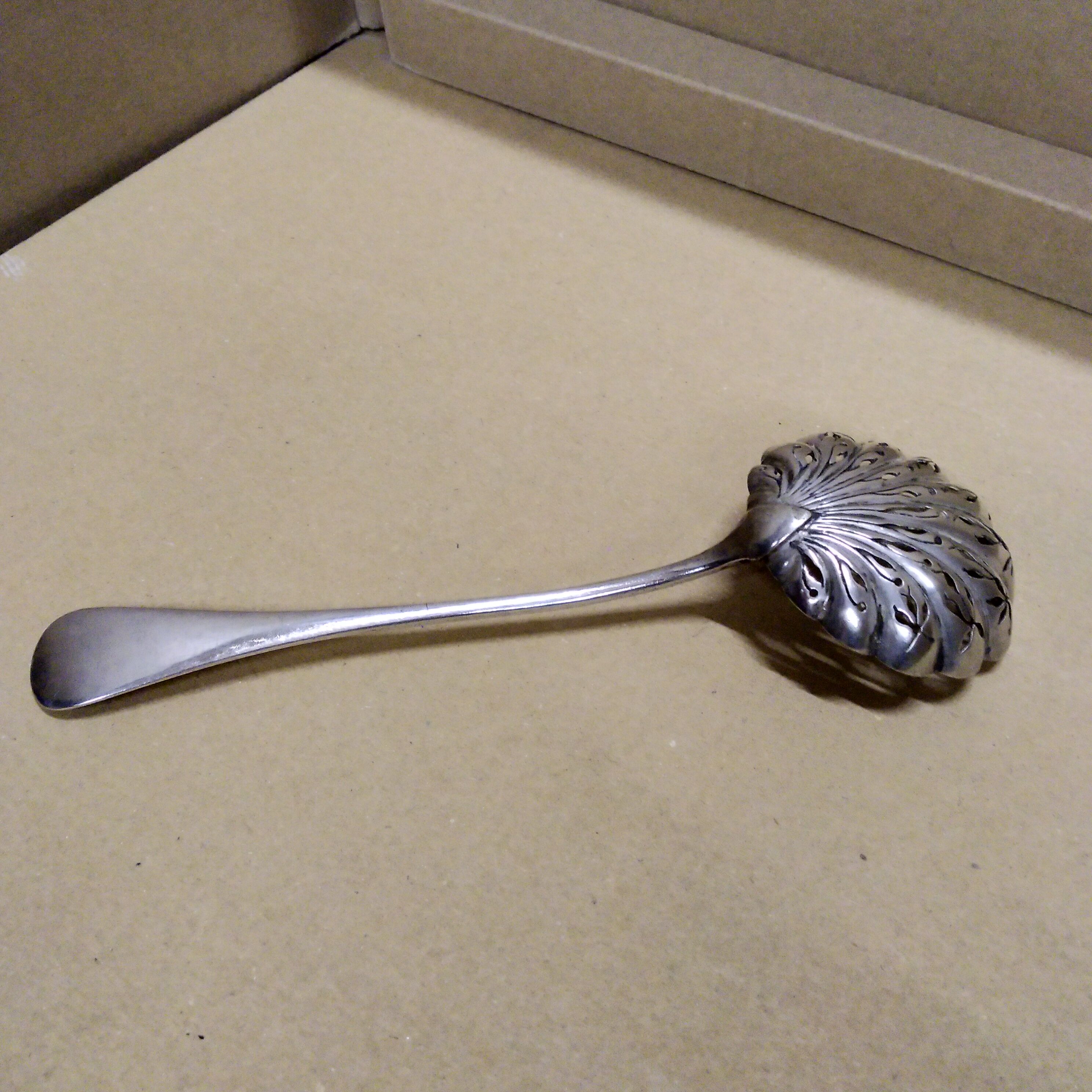Service spoon cut out of silver metal