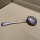 Service spoon cut out of silver metal