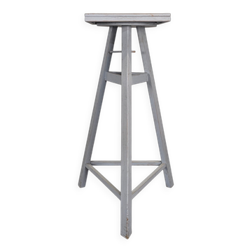 Tripod sculptor's stool in grey painted wood with a rotating top.